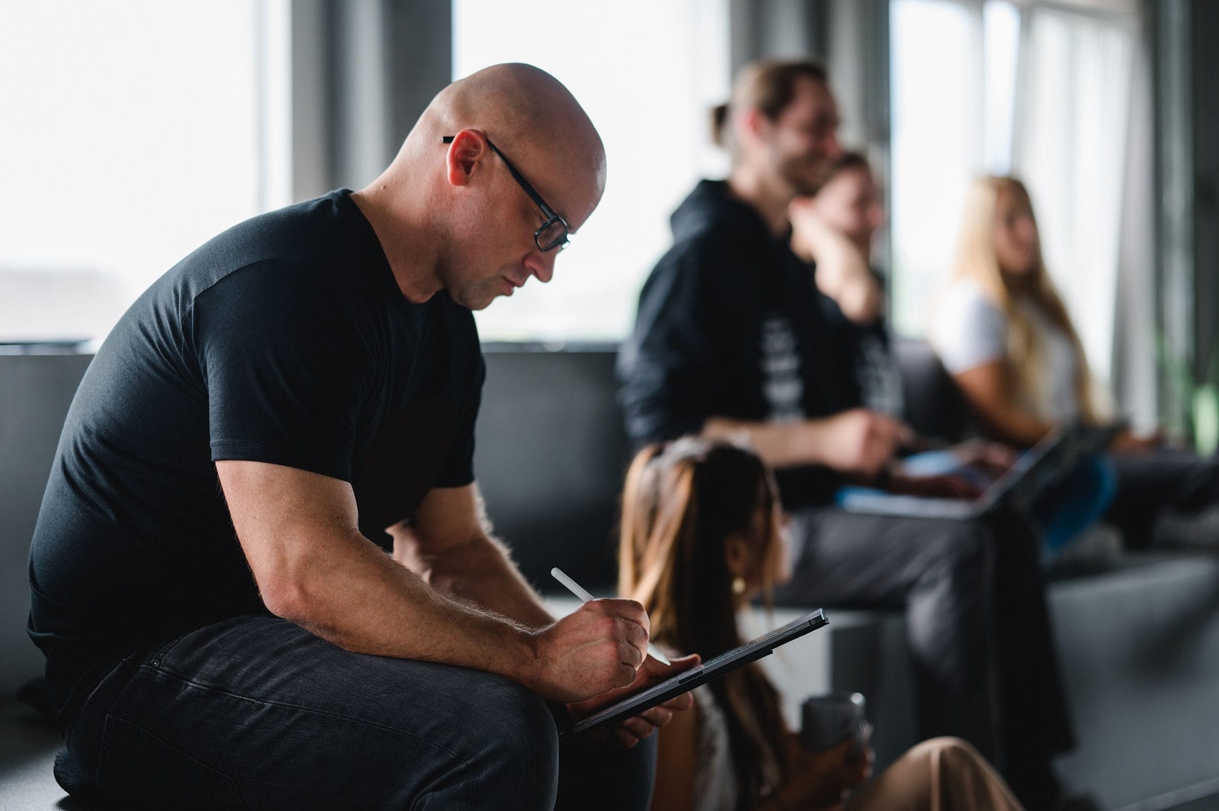 Ein Mitarbeiter von disphere notiert sich wichtige Infos aus einem Team-Meeting